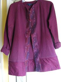 a purple jacket hanging up on a door with space printed on the front and bottom