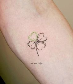 a small four leaf clover tattoo on the arm