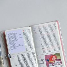 an open book sitting on top of a white table next to a pen and marker