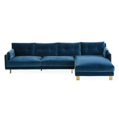 a blue sectional couch sitting on top of a white floor