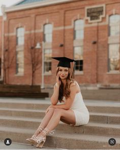 a woman in a graduation cap sitting on steps