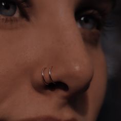 a woman's nose with two piercings on her nose and one in the middle