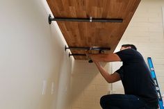 a man working on a wooden ceiling in a room