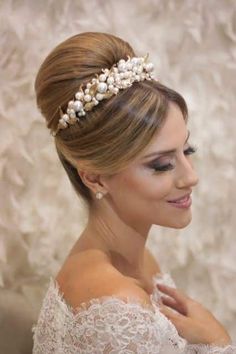 a woman wearing a bridal hair piece with pearls on it's head and shoulder