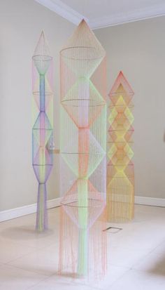 an art installation consisting of multicolored objects in a room with white flooring