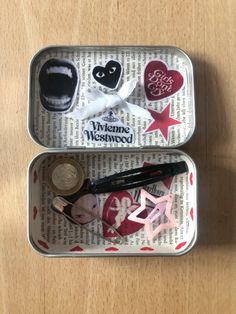 two tins filled with different items on top of a wooden table