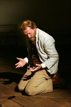 a man sitting on the ground with his hands out