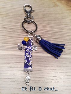 a keychain with a cross and flower design on the front, hanging from a metal chain