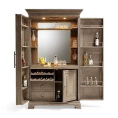 an open wooden cabinet with bottles on the top and shelves below it that has a mirror