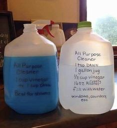 two plastic jugs sitting on top of a counter next to each other with writing on them