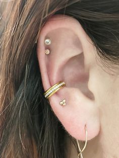 a close up of a person's ear with two different piercings on it