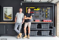 two men standing next to each other in front of a workbench with tools