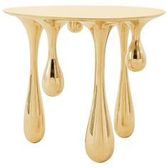 a gold table with three drops on the top and one droplet at the base