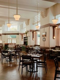 an empty restaurant with wooden tables and chairs