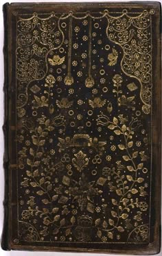 an old book with gold and black designs on it