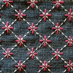 a close up of a piece of cloth with pink and white crosses on it