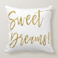 a white and gold pillow with the words sweet dreams written in gold foil on it