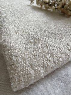 a pile of white rugs sitting on top of a bed