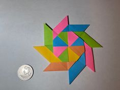 an origami star next to a quarter penny