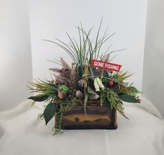 a planter filled with lots of plants on top of a white sheet covered table