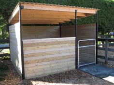 a small wooden shelter sitting next to a fence