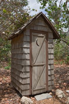 a small outhouse sitting in the woods