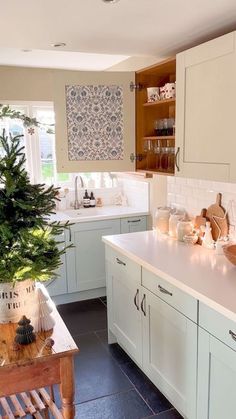 a kitchen filled with lots of counter top space and white cabinets next to a window