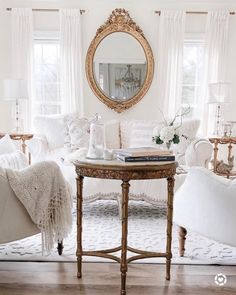 a living room filled with furniture and a round mirror on the wall over a coffee table