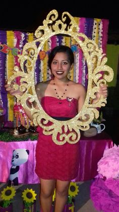 a woman in a red dress is holding up a gold frame with flowers on it