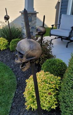 there is a skull and two skis in the yard with bushes around it that look like they are going to fall