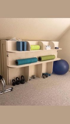 there is a shelf with yoga mats and exercise balls on it in the corner of this room