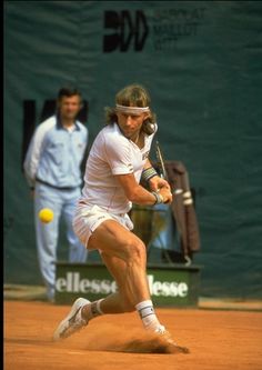 a man hitting a tennis ball with a racquet on top of a court