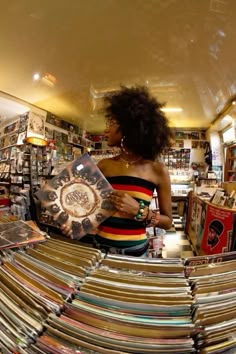 a woman is looking at records in a record store