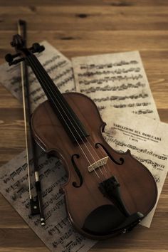 an old violin sitting on top of sheet music