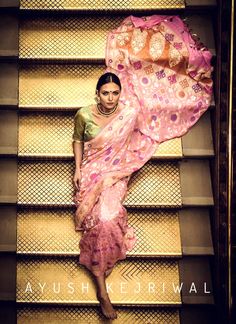 a woman in a sari walking down some stairs