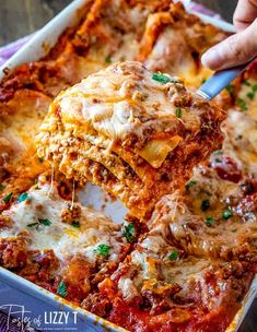 someone is lifting some lasagna out of the casserole dish