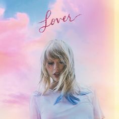 a woman standing in front of a pink and blue sky with the word lover written on it