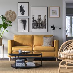 a living room with yellow couches and pictures on the wall above it's coffee table