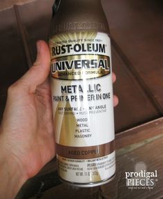 a person holding up a bottle of rustoleum