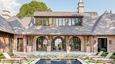 a pool in front of a large stone house