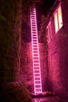 a ladder that is lit up in the dark with words above it and below it