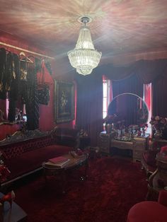 a fancy bedroom with red carpet, chandelier and large mirror on the wall