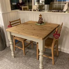 a kitchen table with two chairs and a small christmas tree on top of the table