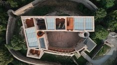 an aerial view of a building in the middle of a forest with trees around it