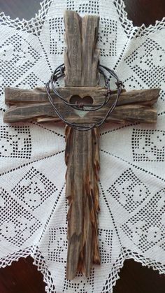 a cross made out of drift wood on top of a doily