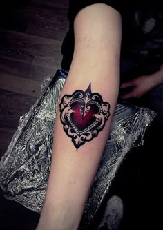 a woman with a heart tattoo on her arm