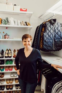 a woman standing in front of a closet full of shoes and handbags on shelves