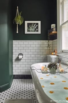 a bathroom with green walls and white tile