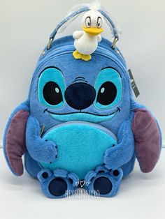 a blue backpack with a white duck on it's back and the face of a cartoon character