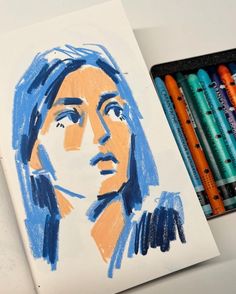 a drawing of a woman's face with crayons next to it